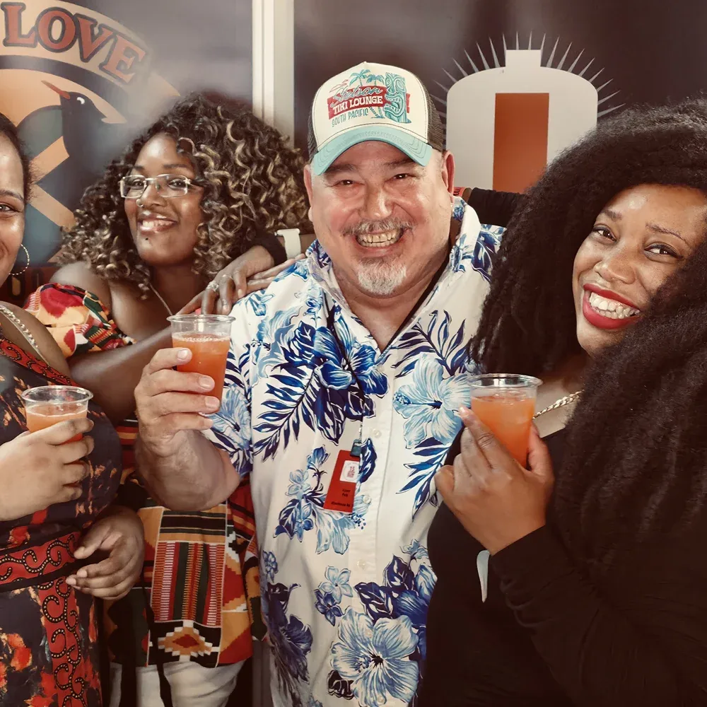 Raising cups of rum punch with fans at the Warehouse #1 stand