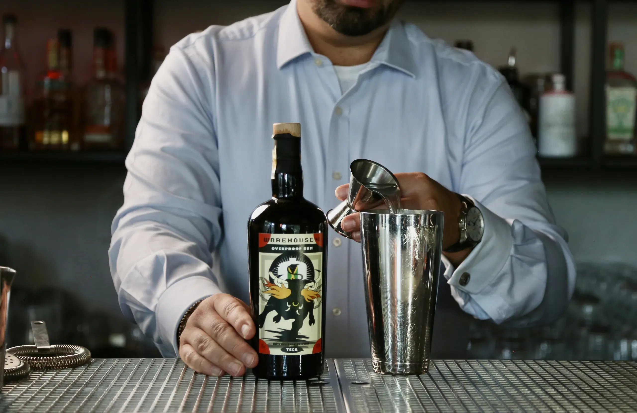 Pouring a Warehouse #1 overproof rum behind the bar
