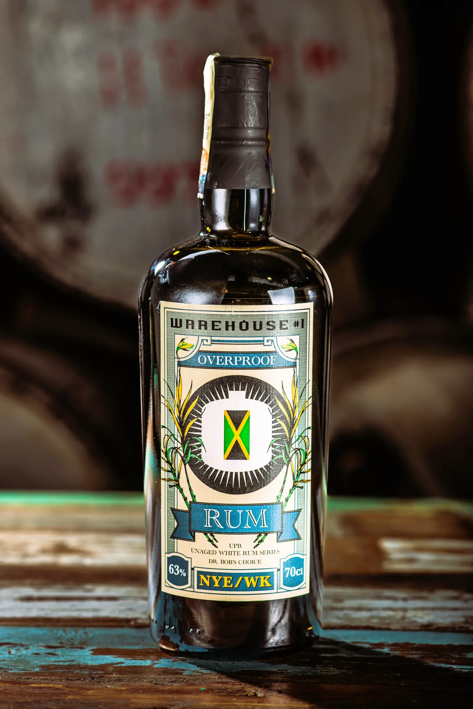 NYE/WK Overproof Rum in front of rum barrels